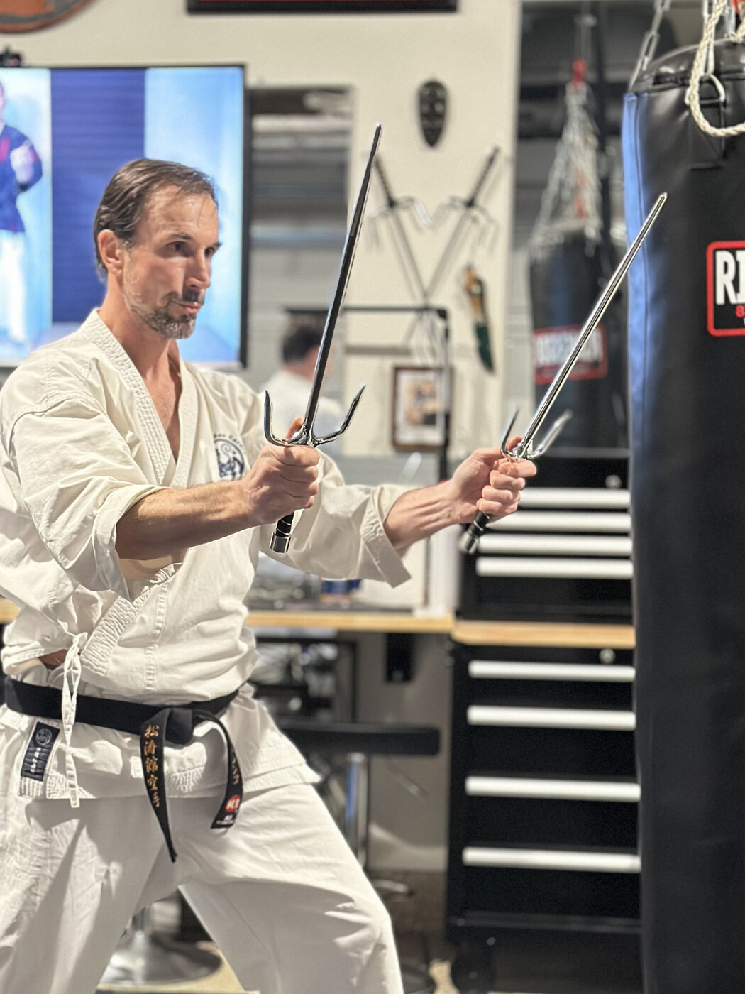 Instructor demonstrating sai weapon kata during a training session